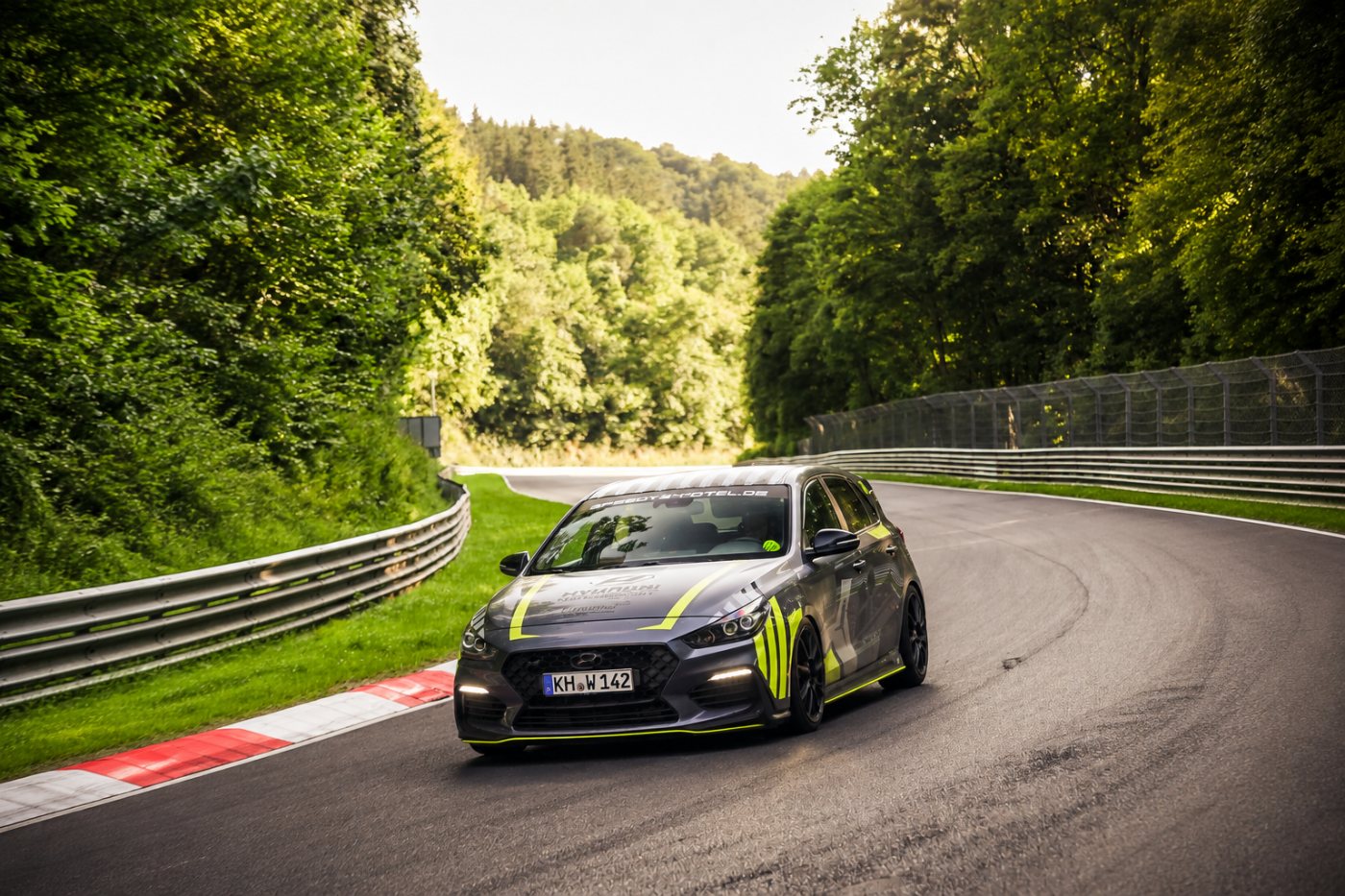Grauer Hyundai i30 N mit neongelben Akzenten in einer Kurve der Nürburgring-Nordschleife